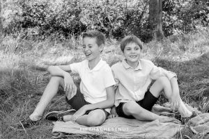 black and white photo of two brothers laughing on a blanket in Truckee, CA