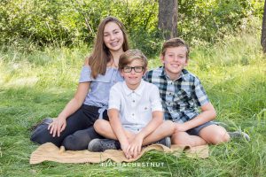 brothers and sister smile together for a truckee family portrait