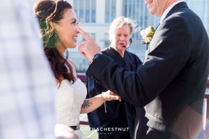 Groom wipes a tear from his bride's eyes