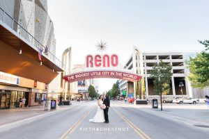 Bride and groom smile under the reno arch on their wedding day