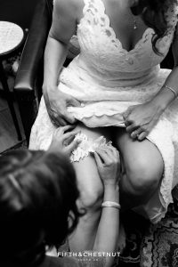 Bride's sister puts her garter on before the first look of a North Lake Tahoe Wedding by Lake Tahoe Wedding Photographer