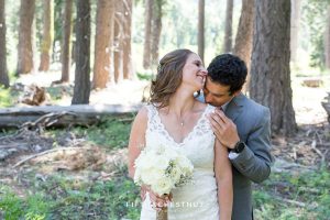 Groom kisses bride lightly on her shoulder after their sweet West shore wedding first look