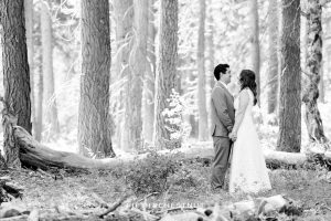 black and white portrait of bride and groom holding hands in the forest after their West shore wedding first look