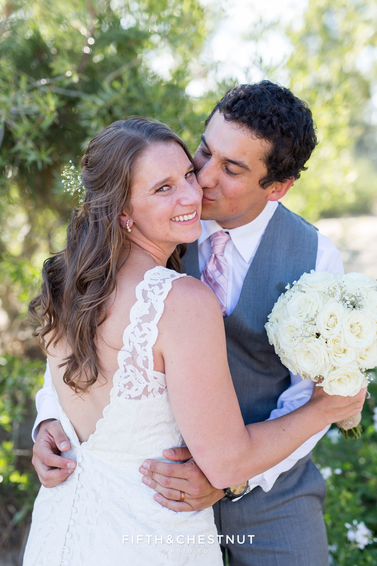 Groom kisses his bride on the cheek as she looks at the camera for their North Lake Tahoe Wedding by Tahoe Photographer