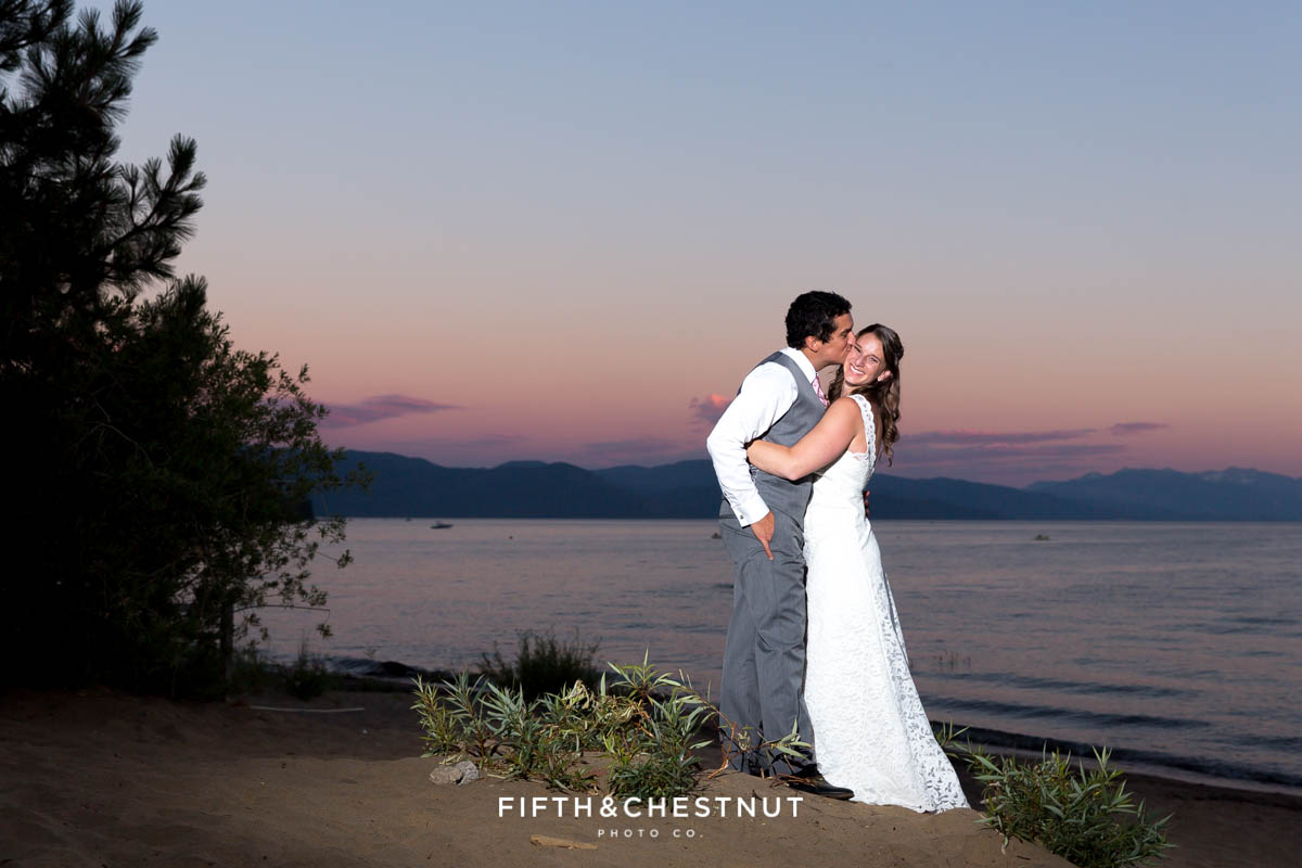 Bride and groom embrace on the beach for a sunset photo at their North Lake Tahoe Wedding by Tahoe Photographer
