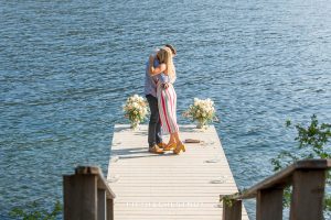 Newly engaged couple hug on the end of a romantic dock on Donner Lake after their marriage proposal