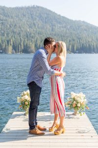 Newly engaged couple kissed with Donner Lake and trees in the background after their Donner Lake Proposal