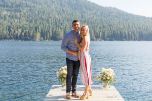 Couple poses for portrait on decorated dock after they became engaged