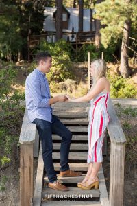 Newly engaged couple holds hands on steps leading to a private dock in Donner Lake after their Donner Lake Proposal