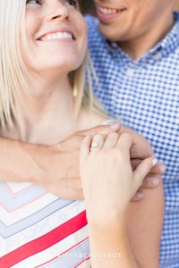 bride-to-be looks up to her groom as she shows off her gorgeous engagement ring