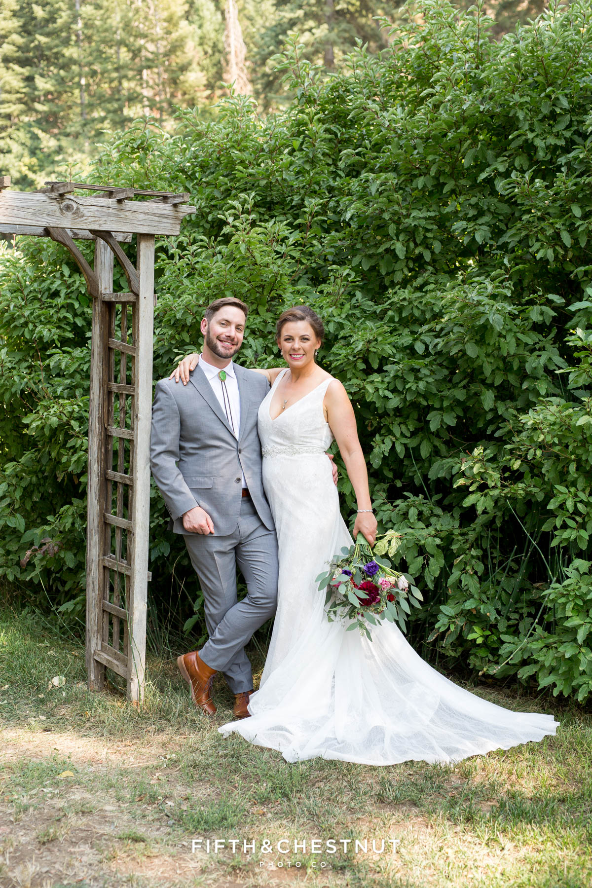 bride and groom stand near an old arbor for Greenhorn Creek Guest Ranch Wedding portraits