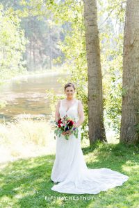 bride in front of a pond for her bright and summery wedding bouquet for a Greenhorn Creek Guest Ranch Wedding