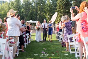 bride walks down the aisle with her father and mother for a Greenhorn Creek Guest Ranch Wedding