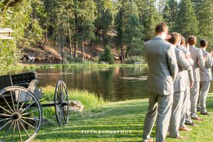 guests watch horses run behind the pond at a Greenhorn Creek Guest Ranch Wedding