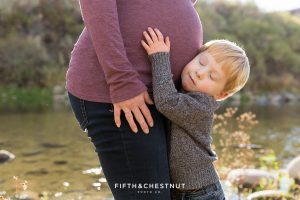 Little boy hugs his mama's belly for Mayberry Park Portraits in the fall