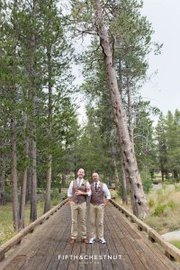 Grooms embrace on wooden path together before their PJ's at Gray's Crossing wedding