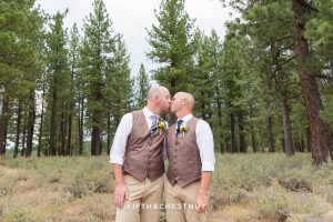 Grooms kiss in an open field after their Truckee Wedding at PJ’s at Gray’s Crossing