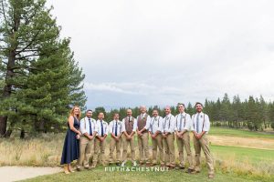 Wedding party stands together under stormy skies at a same-sex wedding in Truckee