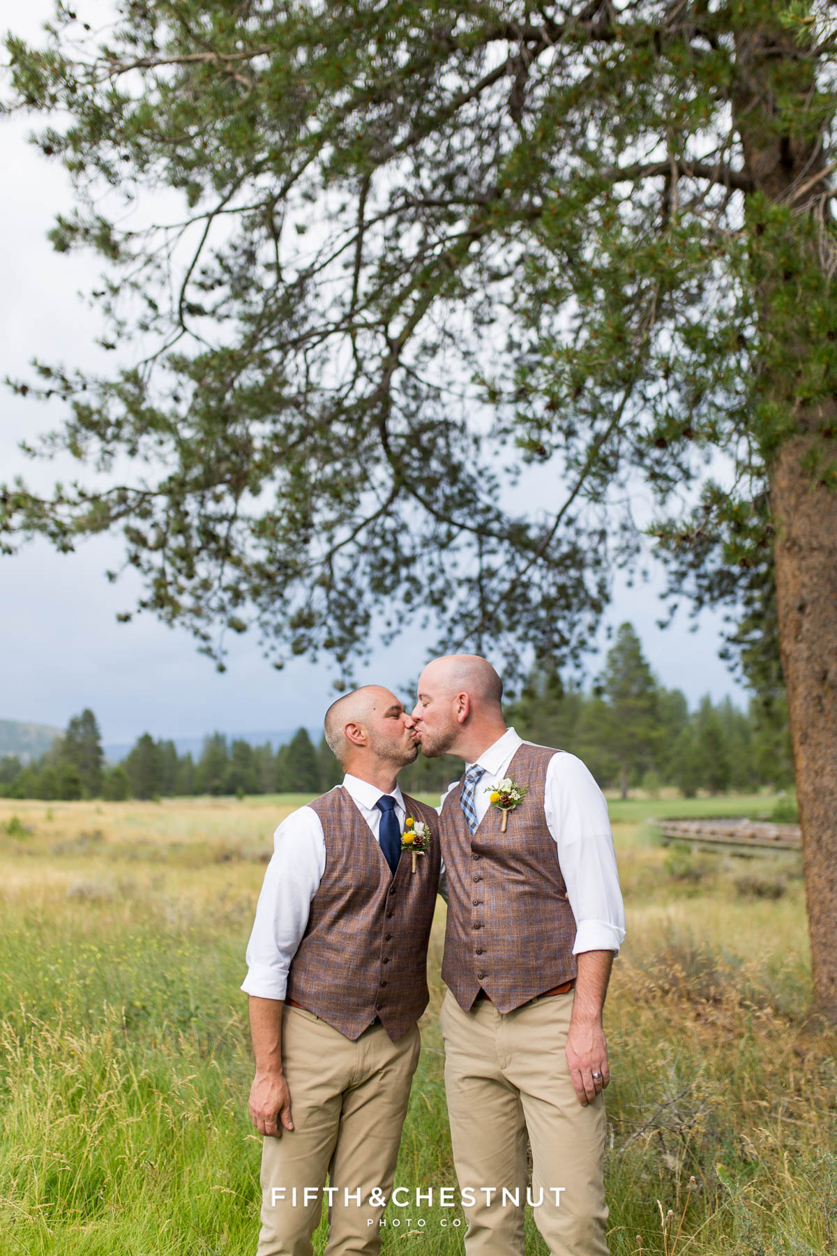 Grooms kiss under a moody sky for their gay wedding at PJ’s at Gray’s Crossing in Truckee