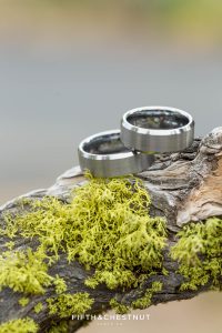 Grooms' rings sit on moss for their PJ's at Gray's Crossing wedding