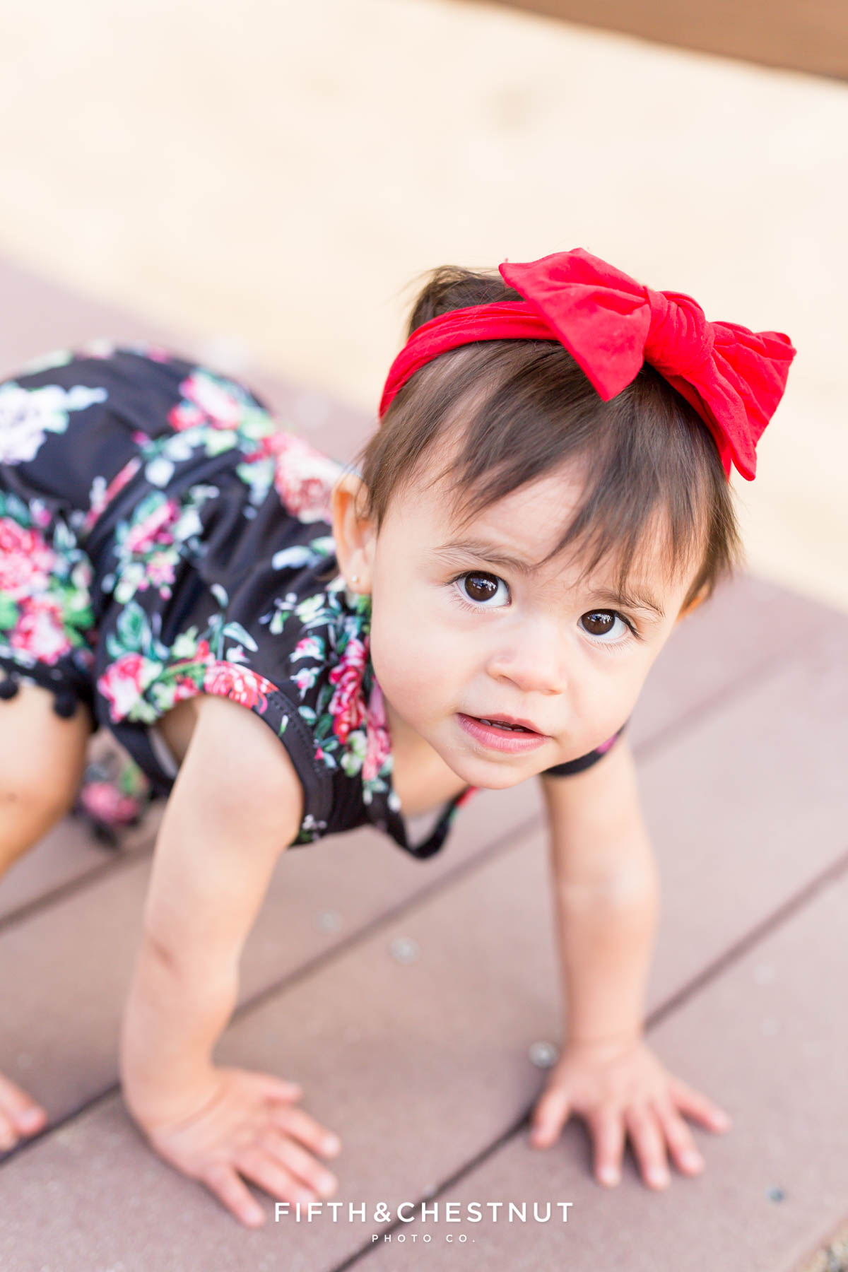 One year old girl wearing a black floral romper for her Fashionable One Year Portraits at Sand Harbor in Lake Tahoe