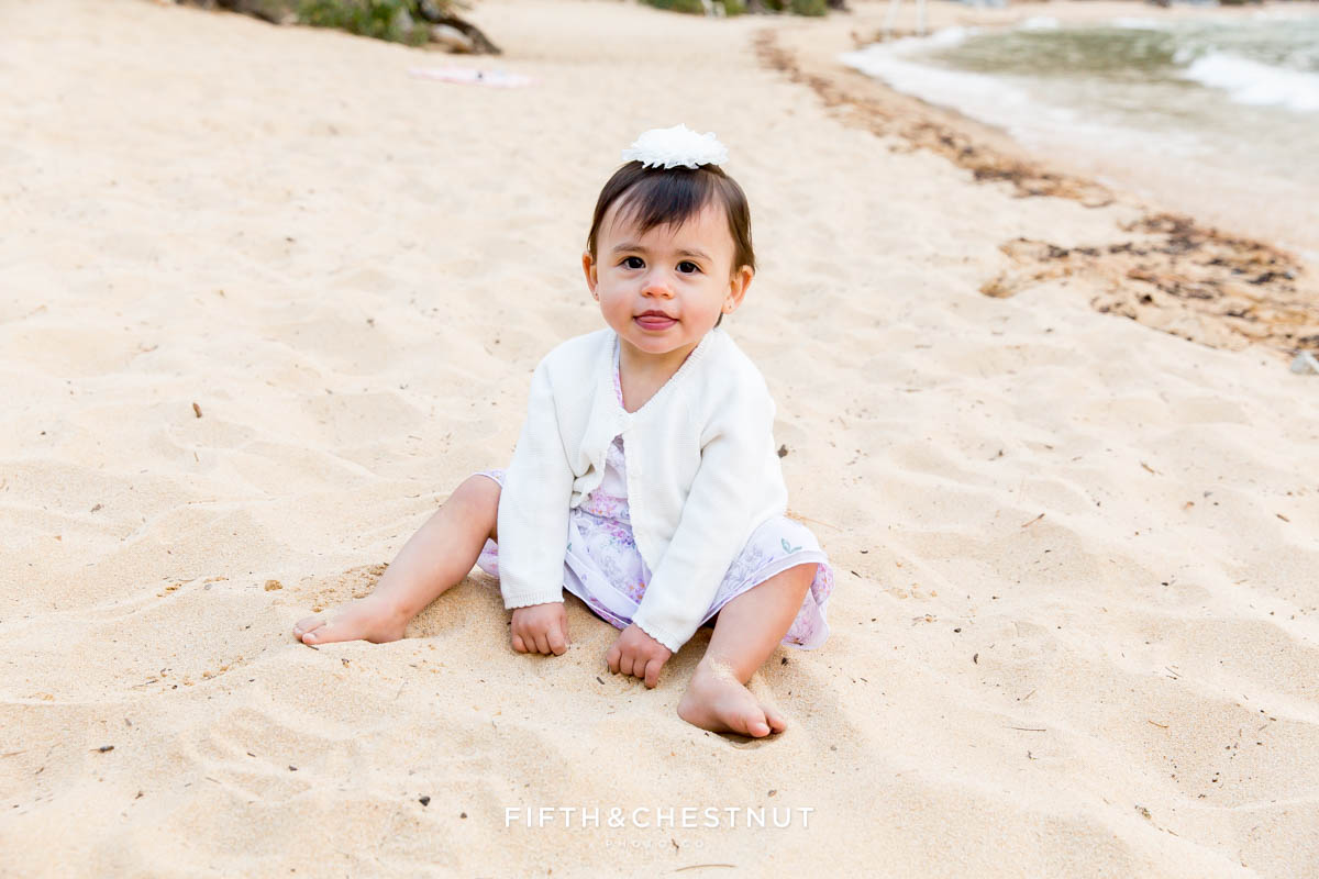 one year old girl plays in the sand wearing a light purple dress for her one year portraits by Reno Child Photographer