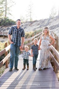 Family holds hands on a wooden path at Sand Harbor for rustic Tahoe Maternity Portraits