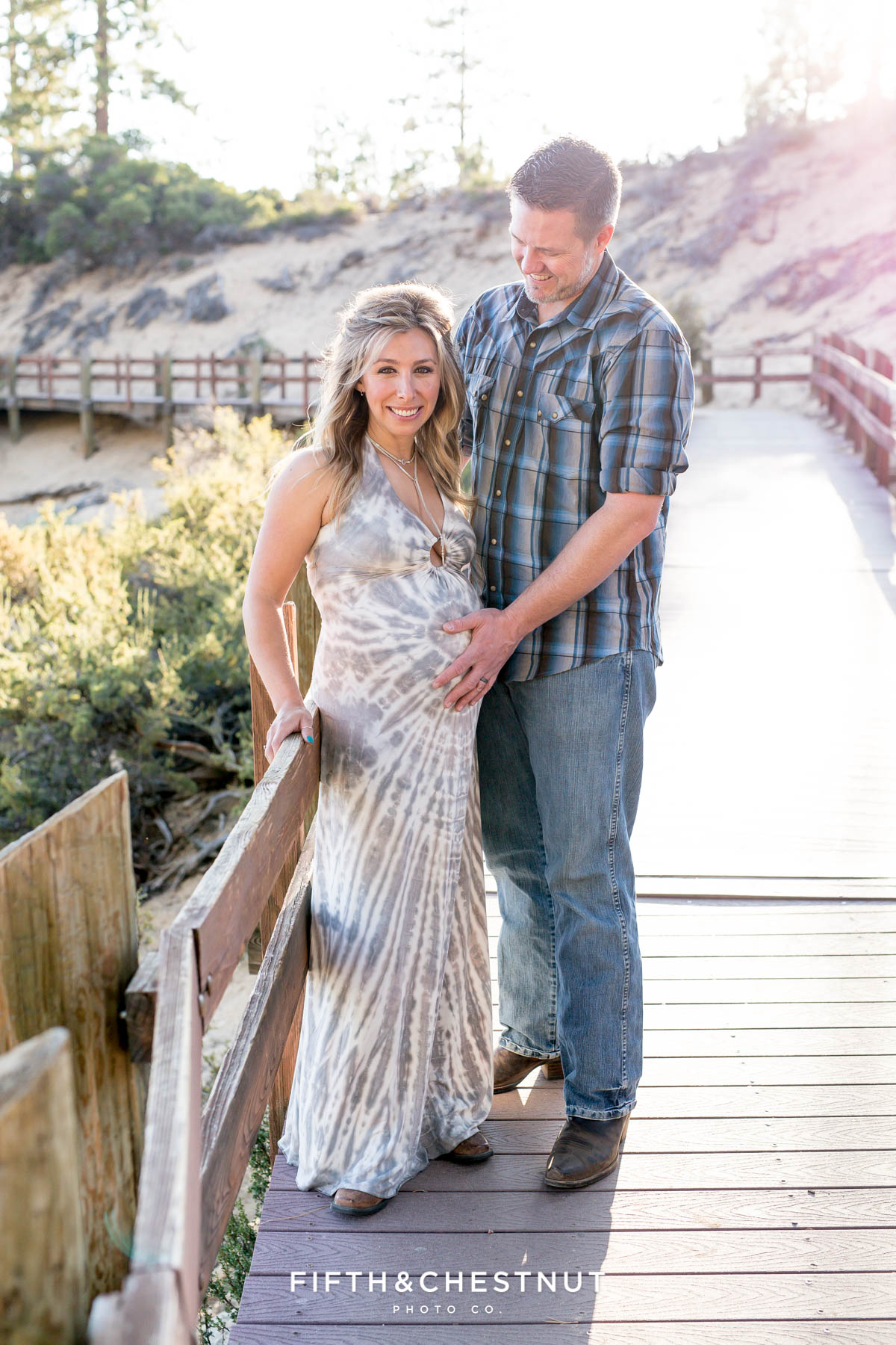 Husband holds his hand on pregnant wife's belly in Sand Harbor for their Tahoe Maternity Portraits