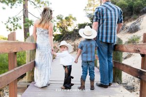 family stands with toddler who is in assless chaps and is looking at the camera