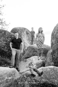 family stands on separate rocks for a cool tahoe maternity portrait at sand harbor
