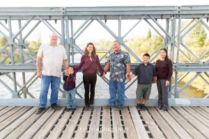 family stands on bridge at mayberry park holding hands in reno, nv