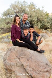 family of four visiting reno from hawaii sit on a big boulder for their vibrant fall  portraits at Mayberry Park