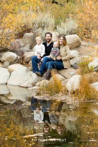A family of four and their reflection in a pond for Fall Galena Creek Portraits by Reno Family Photographer