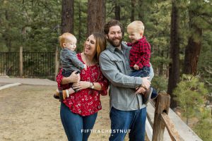 Family of four wearing shades of red and gray for their reno family photos at galena creek park