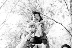 Dad lifts toddler high up into the air for smiles during a Adorable Reno Family Portrait session with Reno Family Photographer
