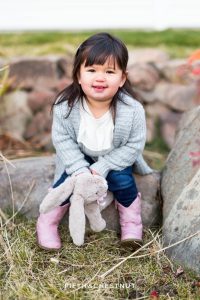 Toddler holds stuffed bunny at Bartley Ranch for her adorable family portraits by Reno Family Photographer