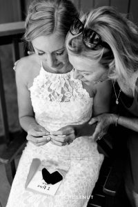 bride cries with her mom after opening a gift from her groom