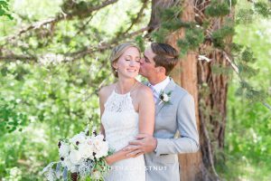 Groom kisses bride on her cheek during their zephyr cove wedding by lake tahoe wedding photographer