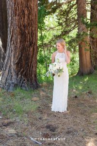 bride fixes hair in the forest before her zephyr cove wedding by lake tahoe wedding photographer