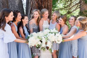 bride and bridesmaids laugh together while showing their bouquets by twine and dandy