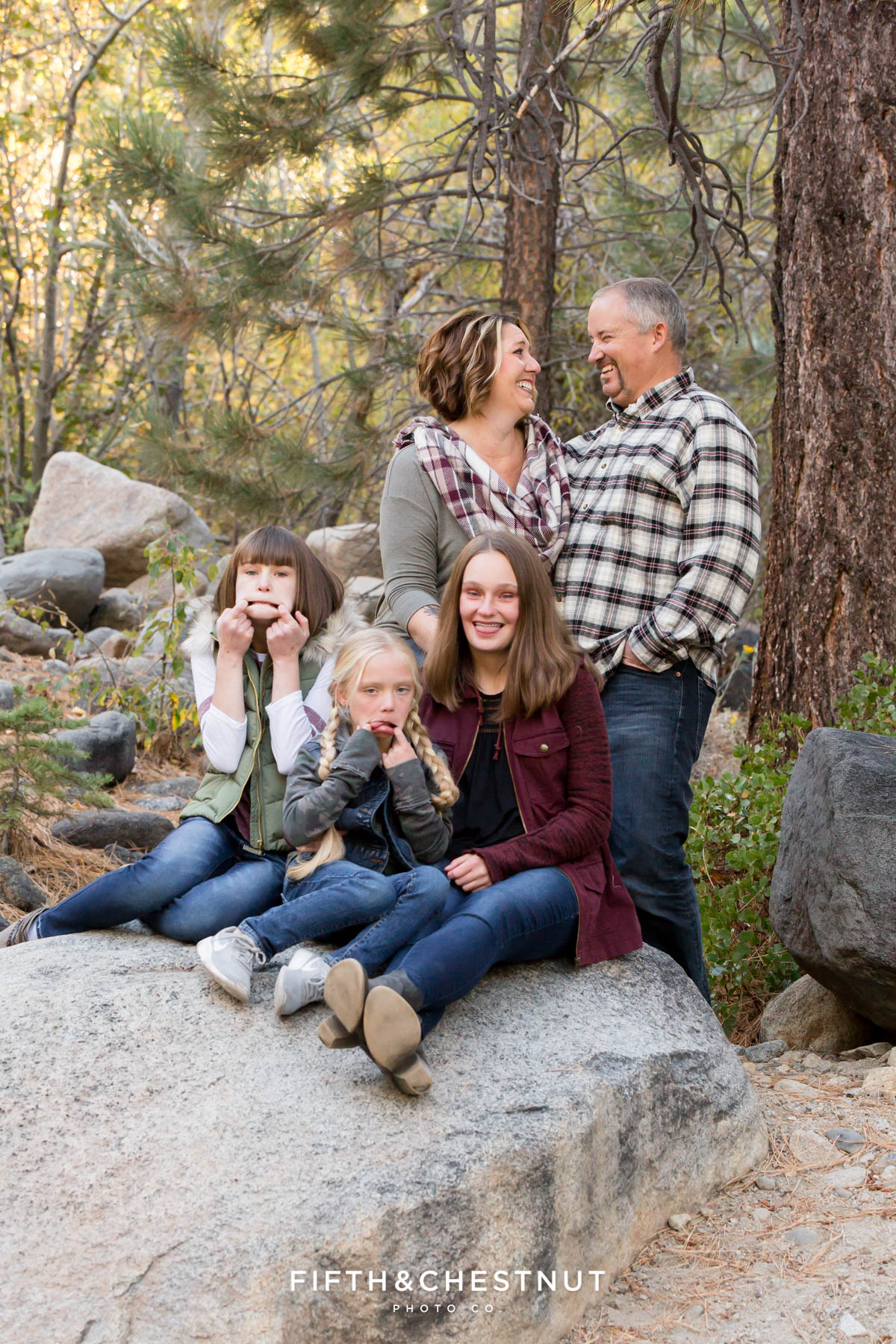 sisters make silly faces while parents look at each other and laugh during Galena Creek Reno fall portraits by Reno family photographer