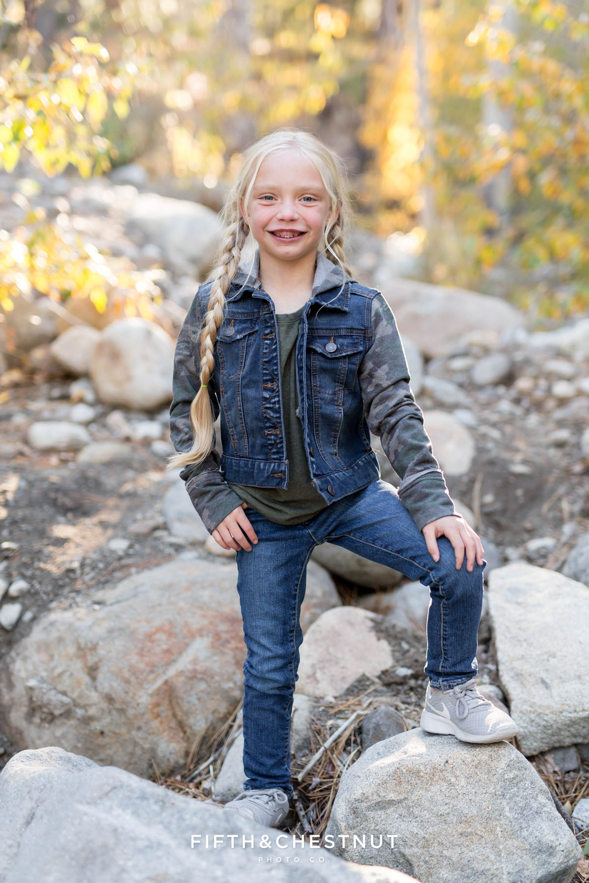 little girl wearing jean jacket poses on rocks for Galena Creek Reno fall portraits by Reno Family Photographer