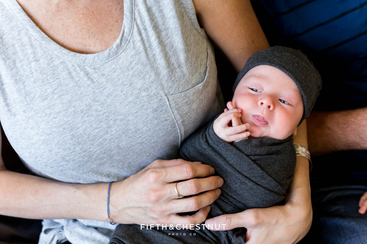 A mother holds her newborn baby boy in her lap for reno newborn photos by Reno Newborn Photographer Fifth and Chestnut Photo Co.