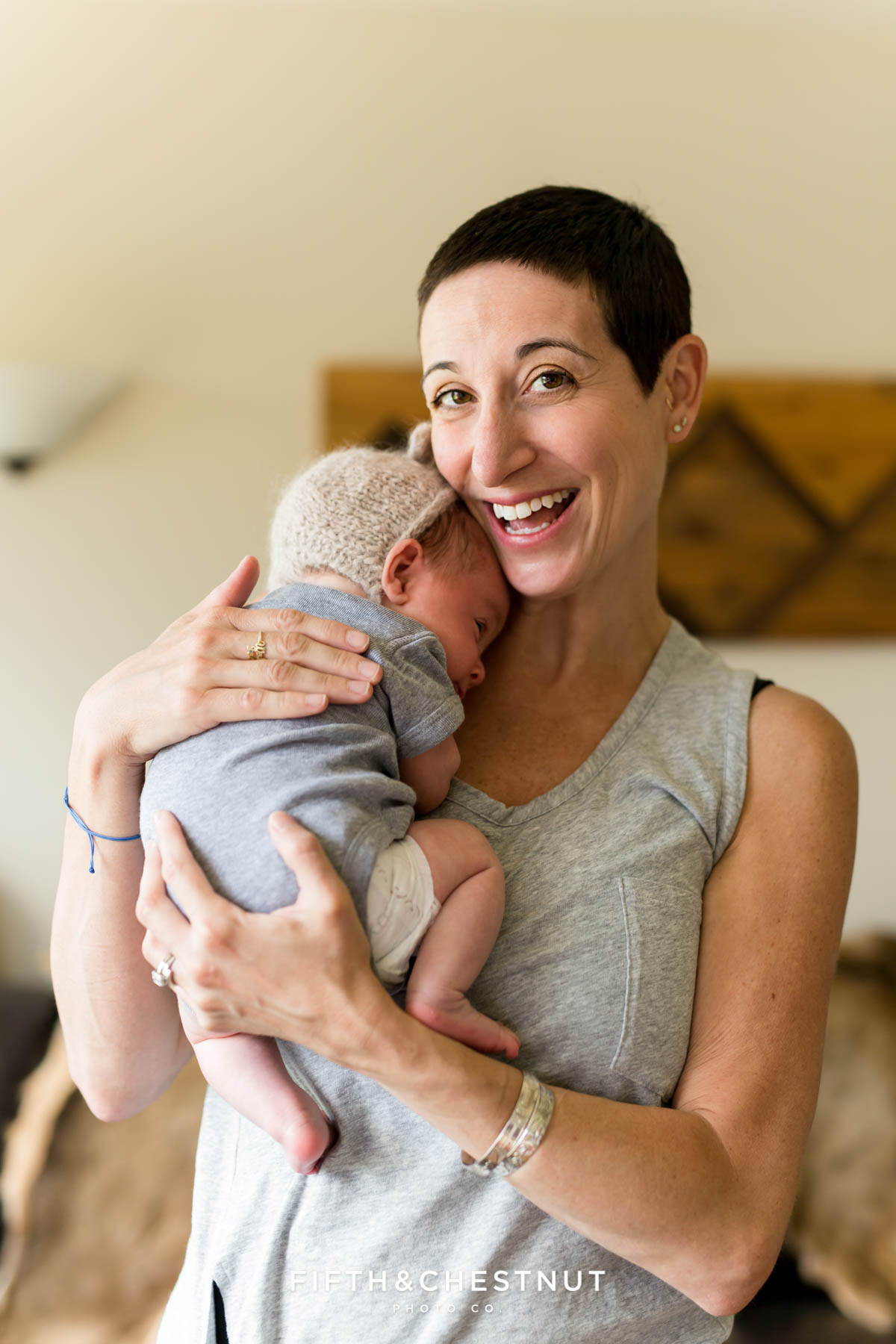 A mother overflowing with joy as she holds her sweet newborn baby boy during his lifestyle reno newborn session with Reno Newborn Photographer Fifth and Chestnut Photo Co.