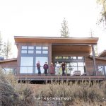 Family of 5 stands on their back balcony overlooking majestic mounatins in the Lake Tahoe foothills