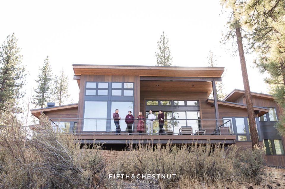 Family of 5 stands on their back balcony overlooking majestic mounatins in the Lake Tahoe foothills
