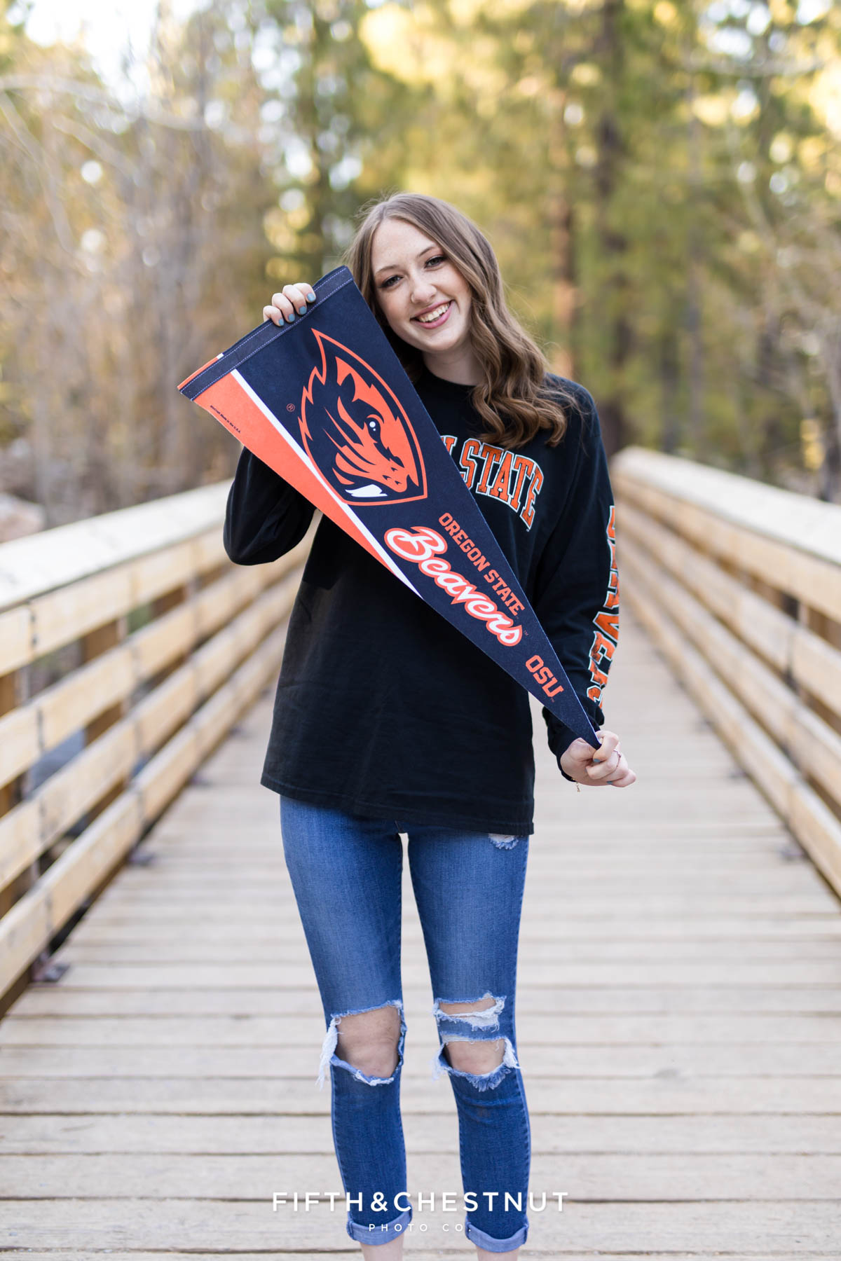 student poses with her college banner in orange and black