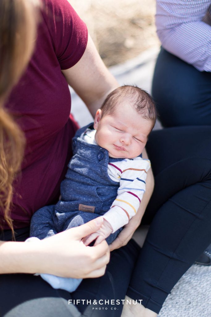 Cute baby boy smiles for spring outdoor newborn portraits by Reno Newborn Photographer