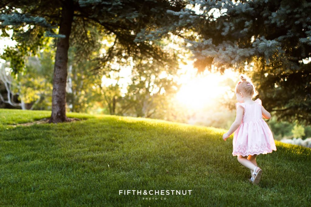 a three year old girl walks up a hill at sunset for some spring wildflower portraits by reno child photographer