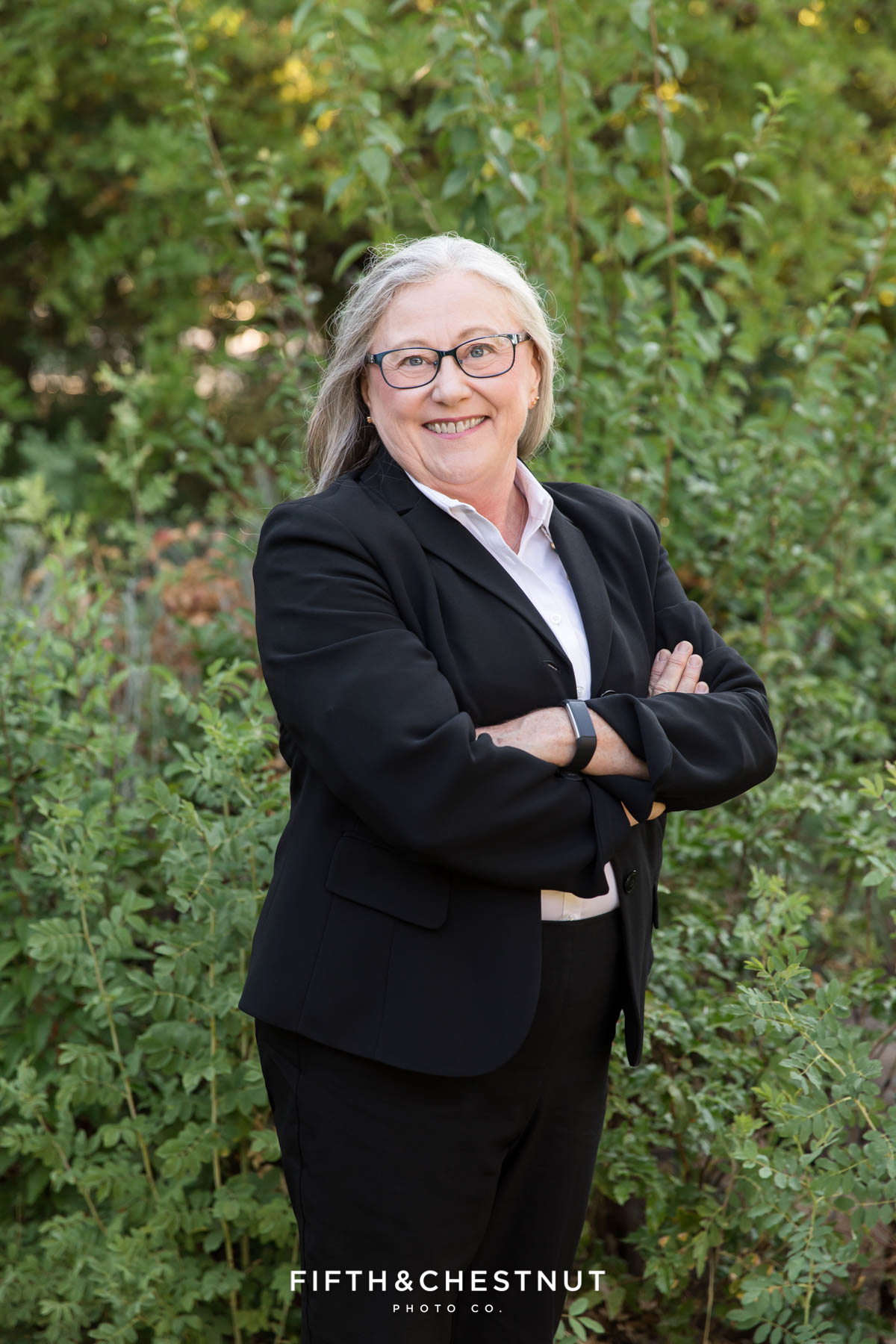 Woman crossing her arms wearing a black suit jacket for professional photos